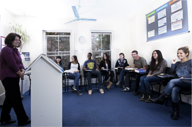 Learners listening to teacher at ABC School of English class.